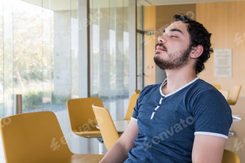 Preview: Happy young male breathing fresh air sitting in the lobby of an office building