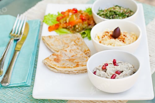 Preview: Assortment of dips: hummus, chickpea dip, tabbouleh salad, baba ganoush and flat bread, pita on a