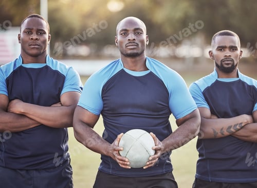 Preview: Portrait three young african american rugby players holding a rugby ball while standing outside on