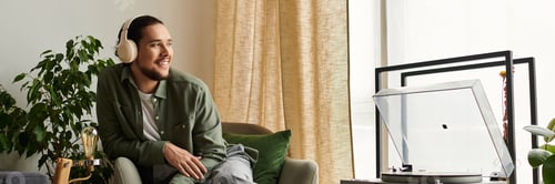 Preview: Young handsome man enjoying relaxing moments at home while listening to music on a weekend