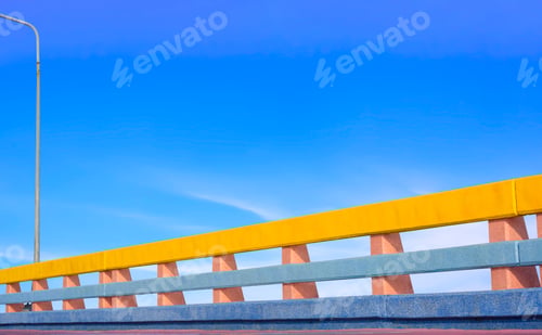 Preview: Row of colorful Bridge railing and sidewalk with street light against blue sky at sea viewpoint