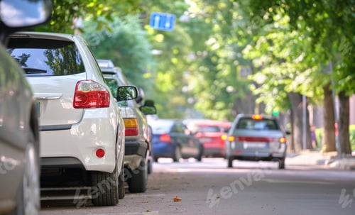 Preview: City traffic with cars parked in line on street side