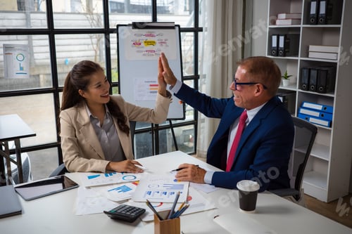 Preview: Business colleagues high fiving celebrating teamwork success in office