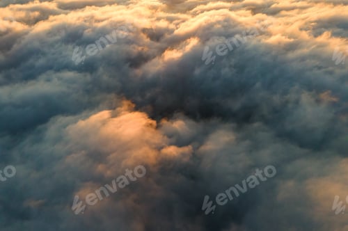 Preview: Aerial view over surface of white dense clouds at sunset.