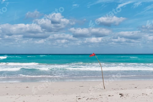 Preview: Red flag on sandy beach of Atlantic Ocean, Varadero, Cuba. Danger sign, swimming is prohibited.
