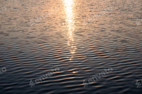 Preview: Sunshine glowing on rippled water in the lake