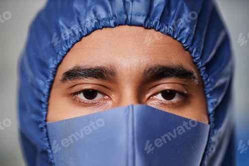 Preview: Medical worker wearing full protective gear looking at camera over mask