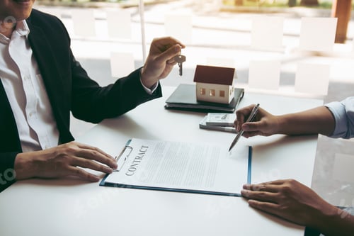Preview: Hand of real estate agent passes the key to new homeowners in office with buyer house concept.