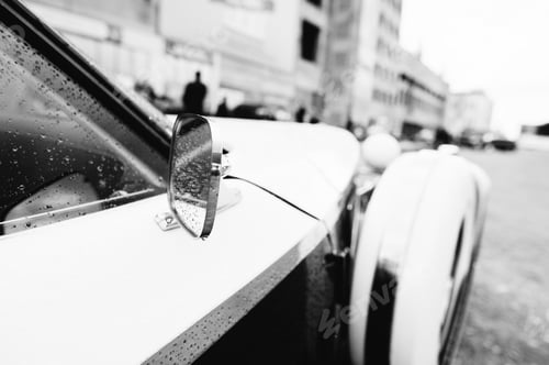 Preview: Side rear-view mirror at old vintage retro car. Black and white photo