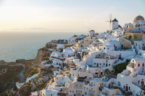 Preview: Sunset with white churches an blue domes by the ocean of Oia Santorini Greece