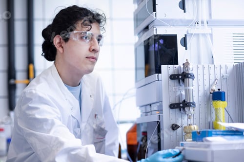 Preview: Focused scientist adjusting equipment in a modern lab