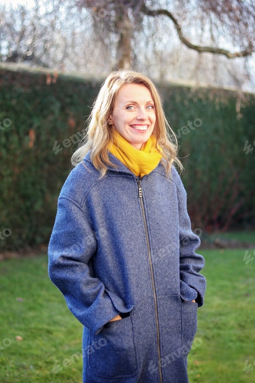 Preview: Portrait of beautiful happy smiling blue eyed woman outdoors in the garden at bright sunny spring