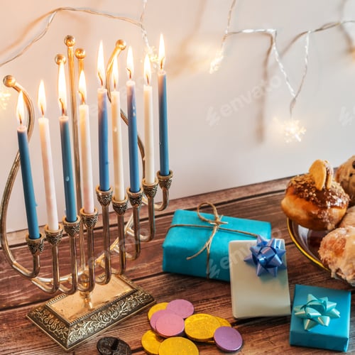Preview: Beautiful shot of a burning Menorah lampstand next to pastry in celebration of Hanukkah
