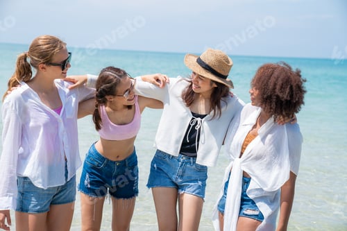 Preview: Happy friends at beach party runs together on the beach having fun.