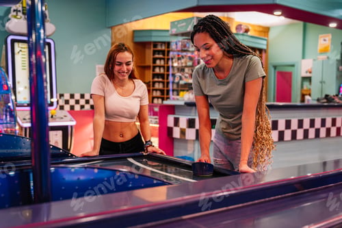 Preview: Two friends playing air hockey in bowling alley arcade game room