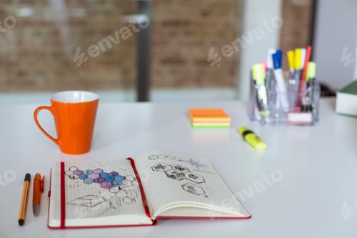 Preview: Notebook with sketch and cup of coffee on desk in office