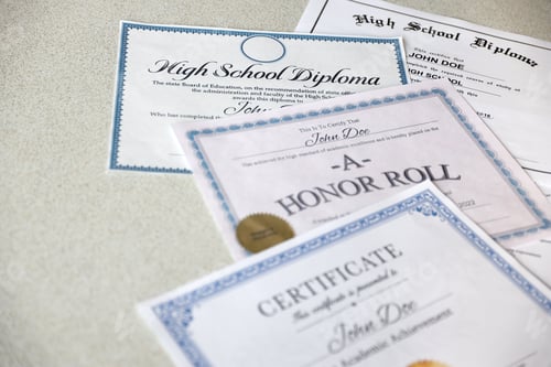 Preview: A honor roll recognition, certificate of achievement and high school diploma lies on table