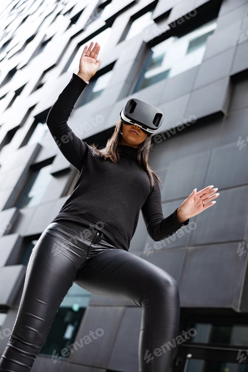 Preview: Focused Woman Gesturing With Virtual Reality Glasses In Futuristic City