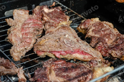 Preview: close up on a grilled piece of meat over a barbecue grill