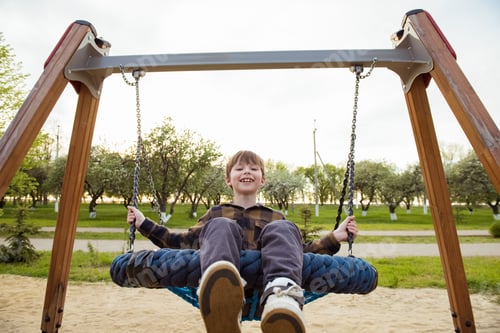 Preview: Happy child boy on swing. Little kid playing in the summer pack