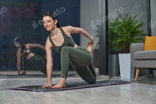 Preview: Happy woman having yoga practice at home after working day.