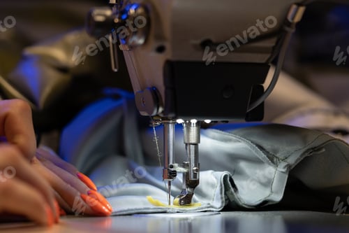 Preview: Closeup of female seamstress, tailor or designer sew on sewing machine. Sewing industry production