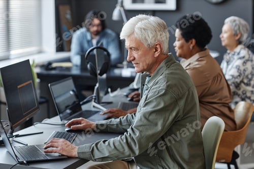 Preview: White haired man using computer in programming class for seniors