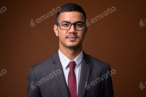 Preview: Young multi-ethnic Asian businessman against brown background