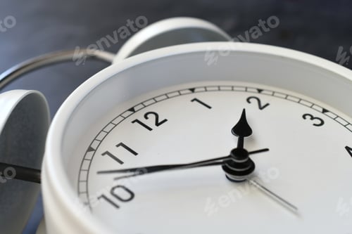 Preview: A classic white alarm clock timepiece at an angle - concept for time change, daylight savings time