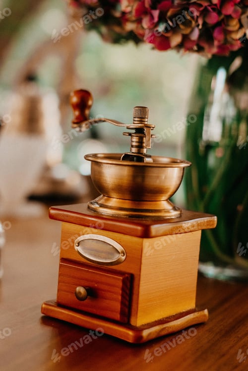Preview: Vintage coffee grinder on a wooden table decorated with flowers during the ceremony