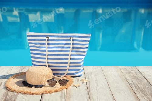 Preview: Beach accessories on wooden deck near outdoor swimming pool, space for text