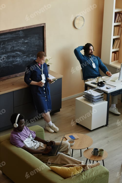 Preview: Three young intercultural office managers using mobile gadgets at break