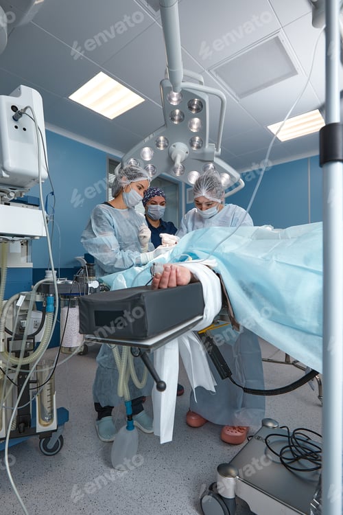 Preview: Concentrated Surgical team operating a patient in an operation theater. Well-trained