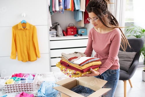 Preview: Woman putting her clothes in a delivery box