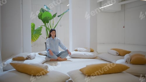 Preview: Serene girl resting lotus position in cozy studio. Calm woman contemplating