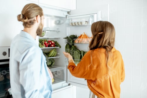 Preview: Vegan couple with fresh vegatables at the kitchen