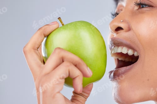 Preview: Apple, black woman and eating with health, diet and natural skincare glow in studio. Happy, face an