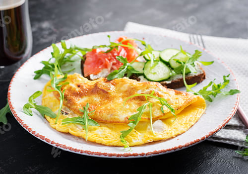Preview: Omelette with cheese and sandwiches with salmon and cucumber on white plate