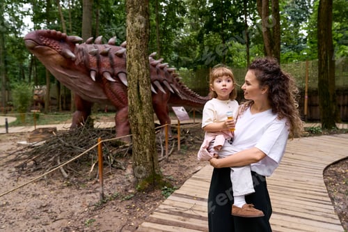 Preview: Joyful moments of a mother and daughter exploring a dinosaur themed amusement park together