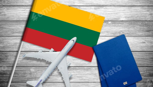 Preview: Flag of Lithuania with passport and toy airplane on wooden background. Flight travel concept