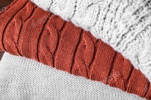 Preview: Stack of folded warm sweaters, closeup view