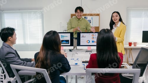 Preview: Asian business team showing charts and statistics on computer monitors during meeting