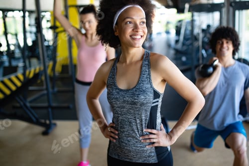 Preview: Group of healthy fit people training in gym