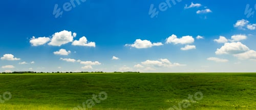 Preview: Panoramic view to green field with clouds in the blue sky