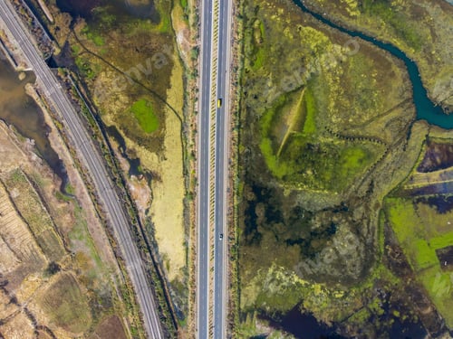 Preview: Bird's eye view of a highway stretching through a beautiful landscape with forests