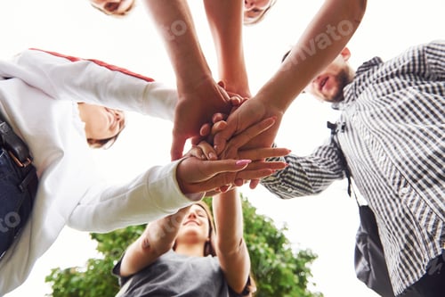 Preview: Close up view of hands of the young team of successful friends outdoors