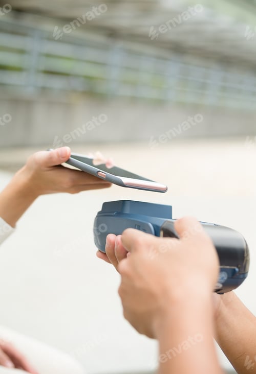 Preview: Woman using mobile phone for paying the bill