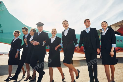 Preview: Near plane. Crew of airport workers in formal clothes standing outdoors together
