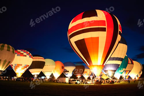 Preview: Hot air balloons lighting up the twilight sky at a festive gathering.