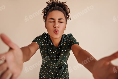 Preview: Adorable black young woman posing with kissing face expression. Studio shot of african american gir